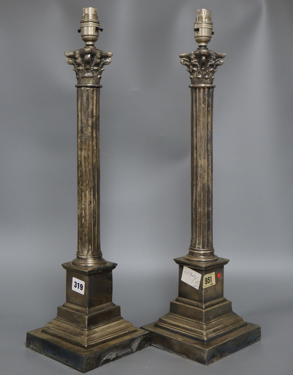 A pair of electroplated corinthian column lamps, height 50cm excluding electrical fittings